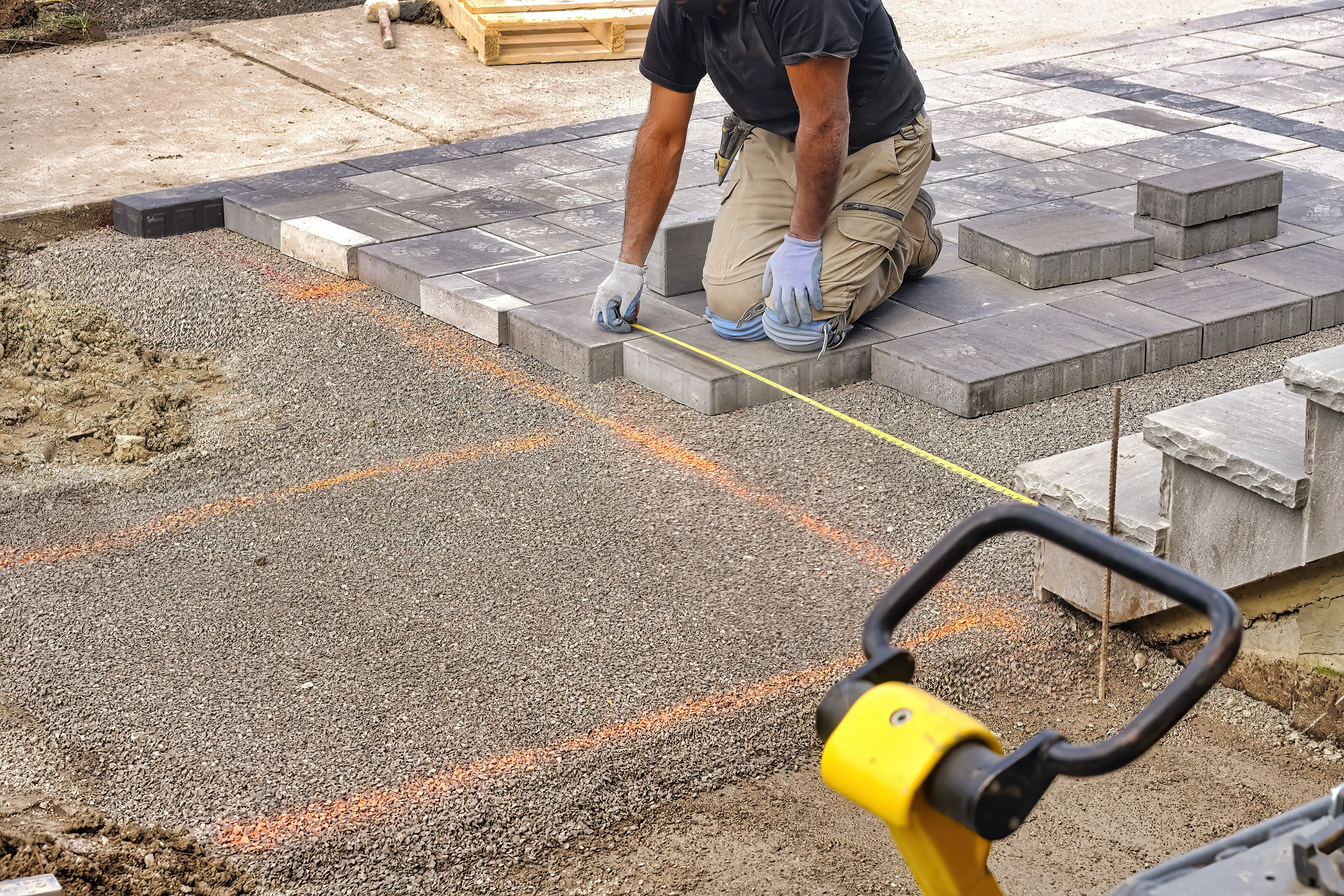 ein Handwerkerker verlegt einen Gehweg